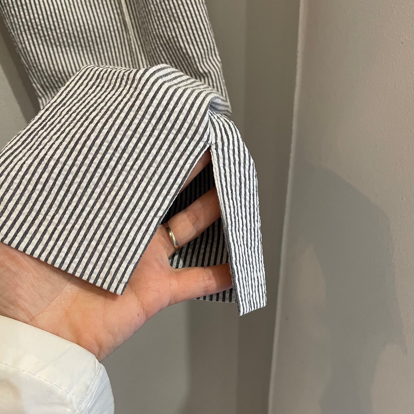 Dettaglio parte finale gamba con taglio laterale. Pantaloni Prada in misto cotone a righe grigio bianco